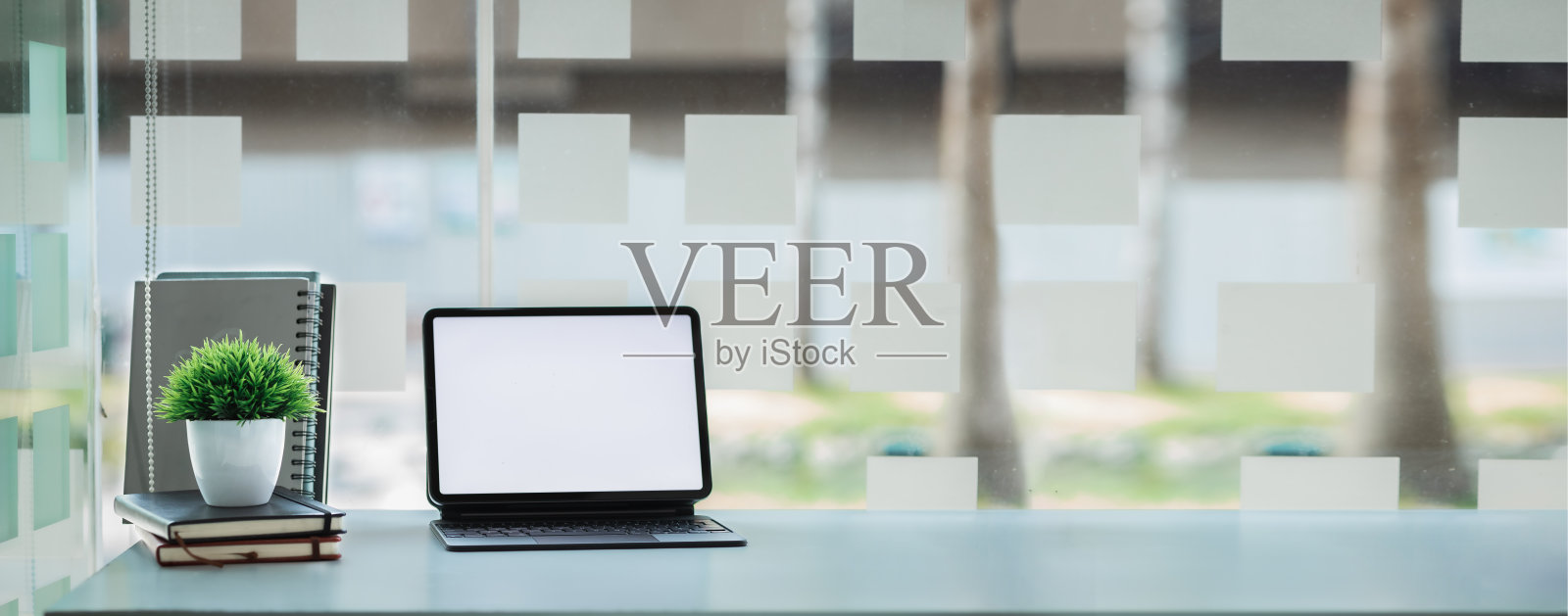 创业公司的办公桌，空白的笔记本电脑屏幕，空办公室，营销人员办公室的办公室，有办公设备的办公桌，窗口办公桌。办公桌安置的想法。照片摄影图片