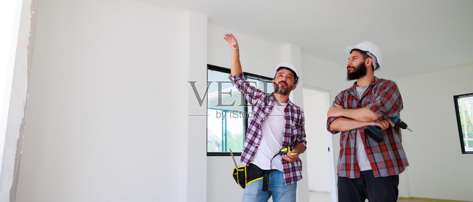 两名施工工程师在施工现场安全统一作业和刨平。维修服务维修和杂工概念照片摄影图片