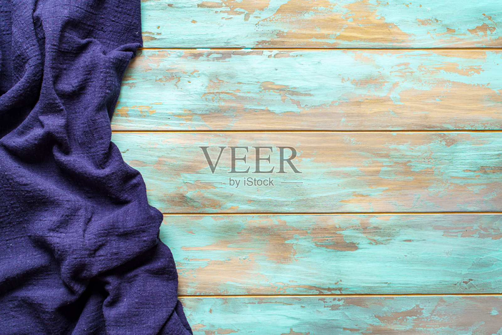 蓝色的桌布放在浅色破旧的木制背景上照片摄影图片