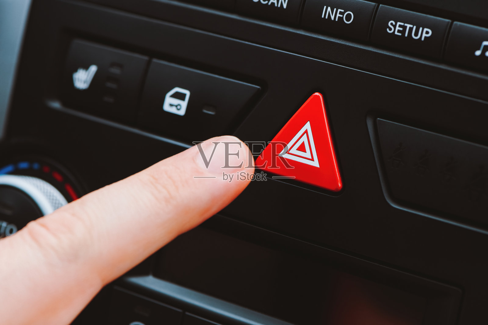 一名男子按下了汽车仪表盘上的三角形紧急按钮。近景与浅景深。照片摄影图片