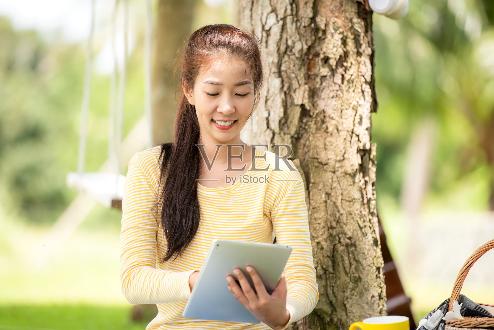 年轻人使用笔记本电脑购物和在线学习，早上喝着咖啡，在自然花园的家里放松照片摄影图片