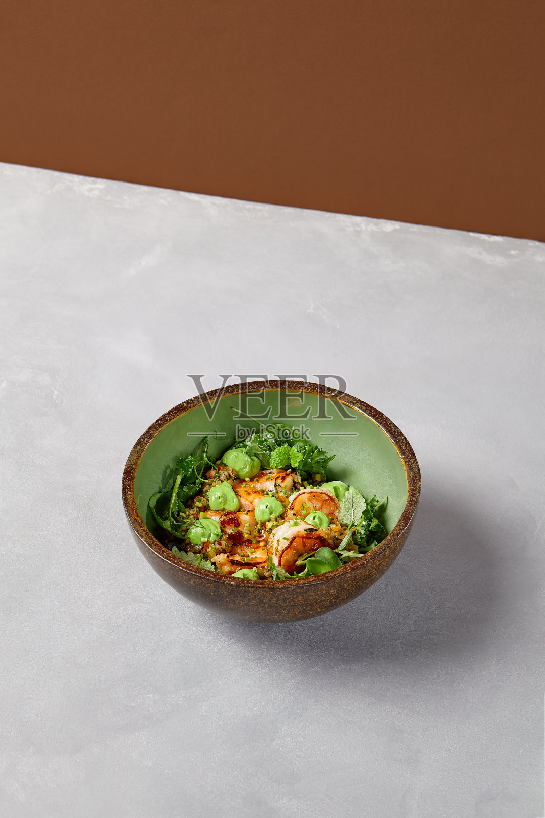 绿色碗与对虾，藜麦和鳄梨奶油手工陶瓷盘子。沙拉虾在黑暗的现代餐具。现代风格的健康食品照片摄影图片