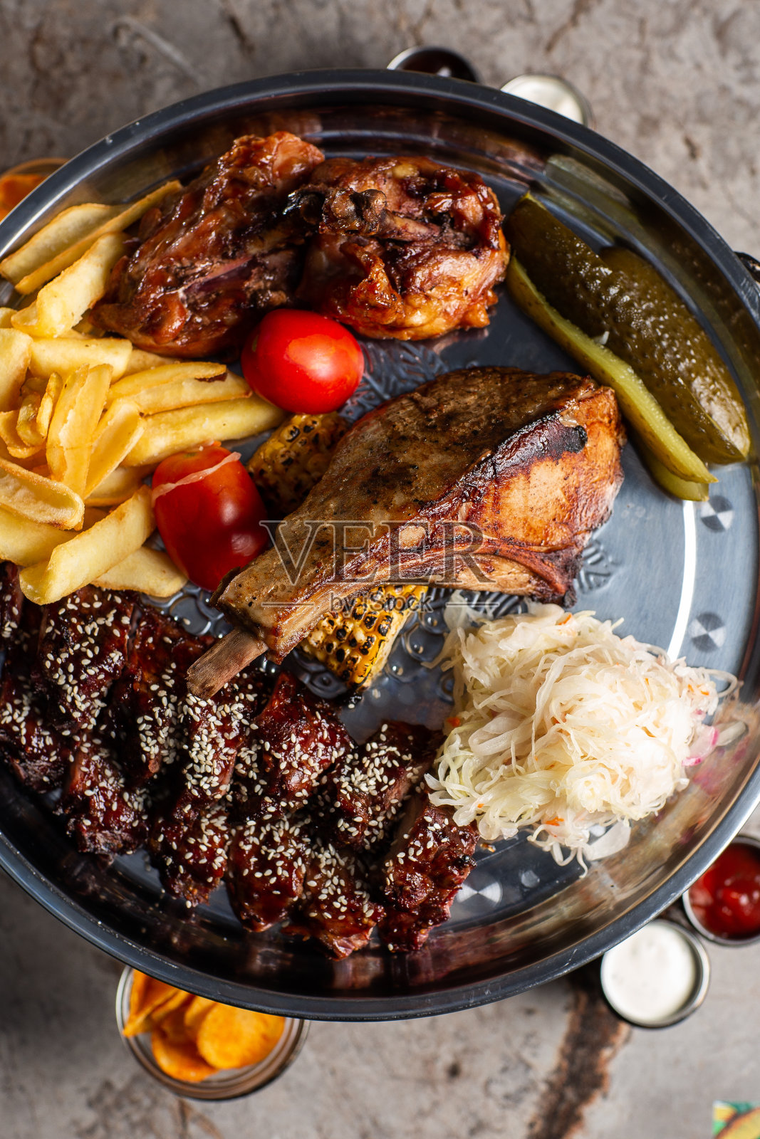 美味肉盘，排骨，烤鸡，香肠，牛肉，烤土豆。什锦美味烤肉配蔬菜和香草照片摄影图片