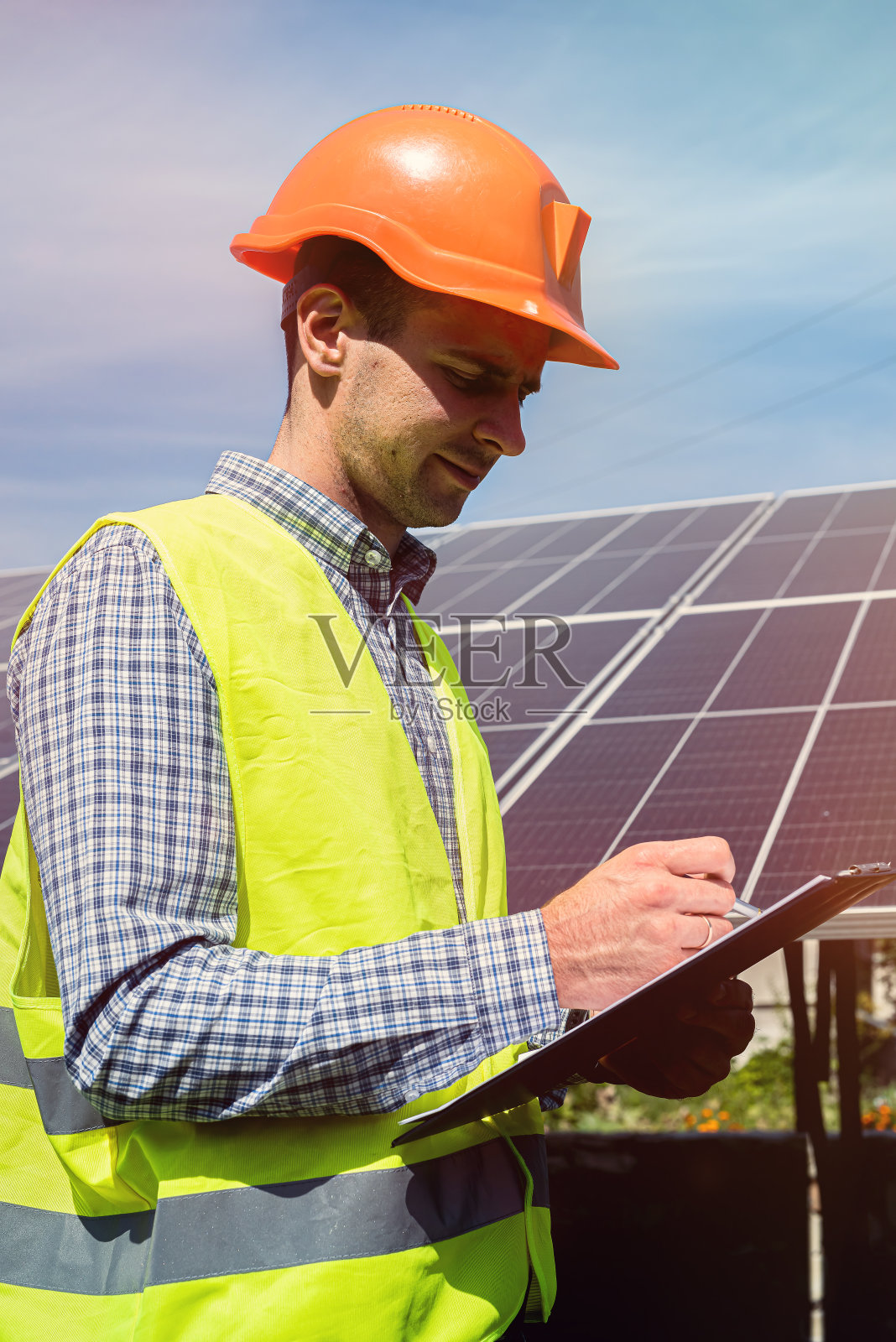 工程师的肖像与蓝图摆姿势附近的太阳能电池板照片摄影图片