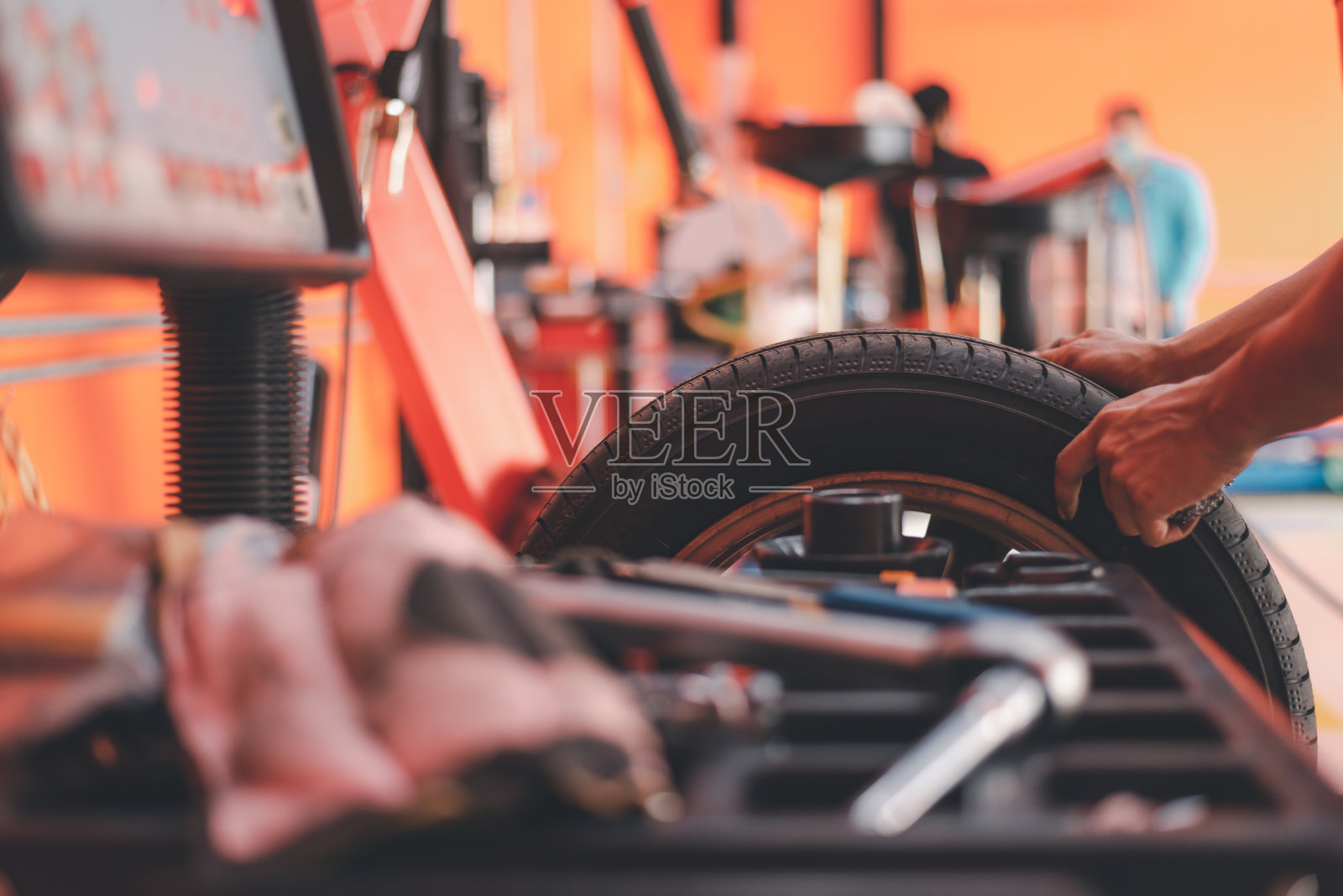 轮胎维修中的汽车车轮平衡。在车间进行汽车车轮平衡工作。照片摄影图片