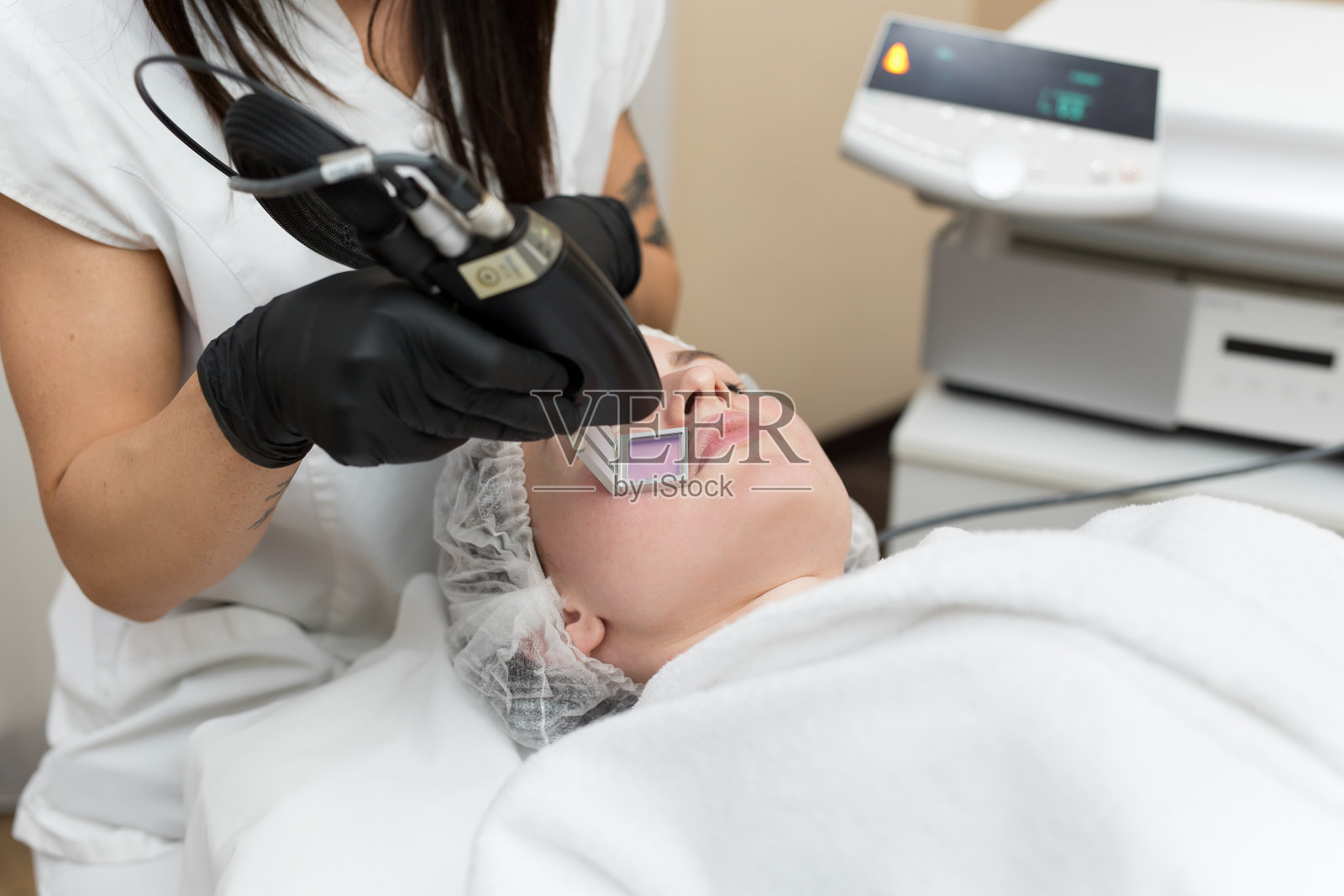 美容spa诊所的治疗师的脱毛美容程序。激光脱毛美容照片摄影图片