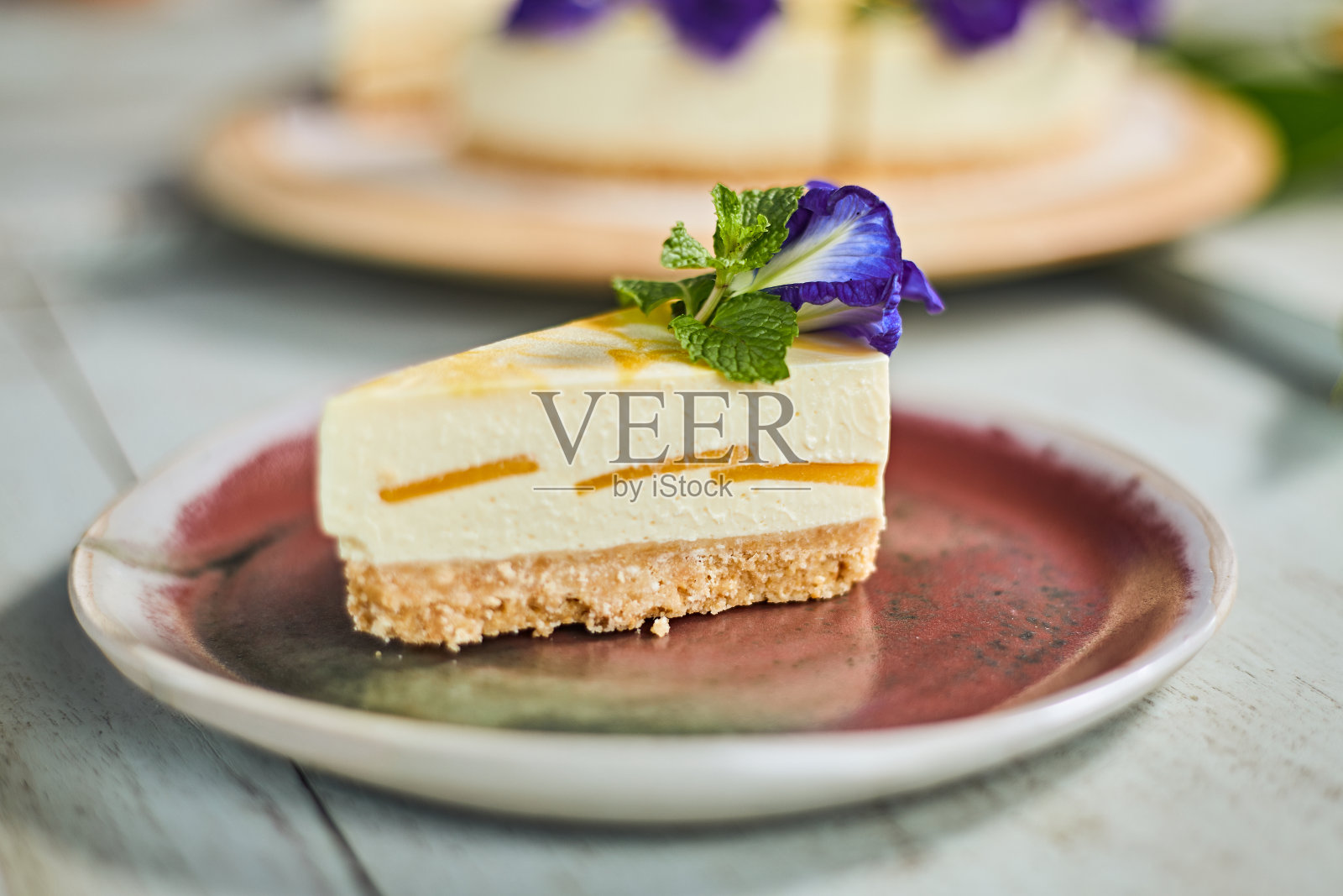 木头背景上的芒果奶酪蛋糕照片摄影图片