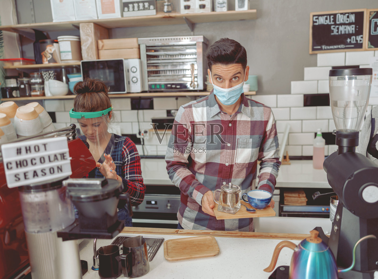 男女咖啡师在大流行期间在咖啡馆工作照片摄影图片