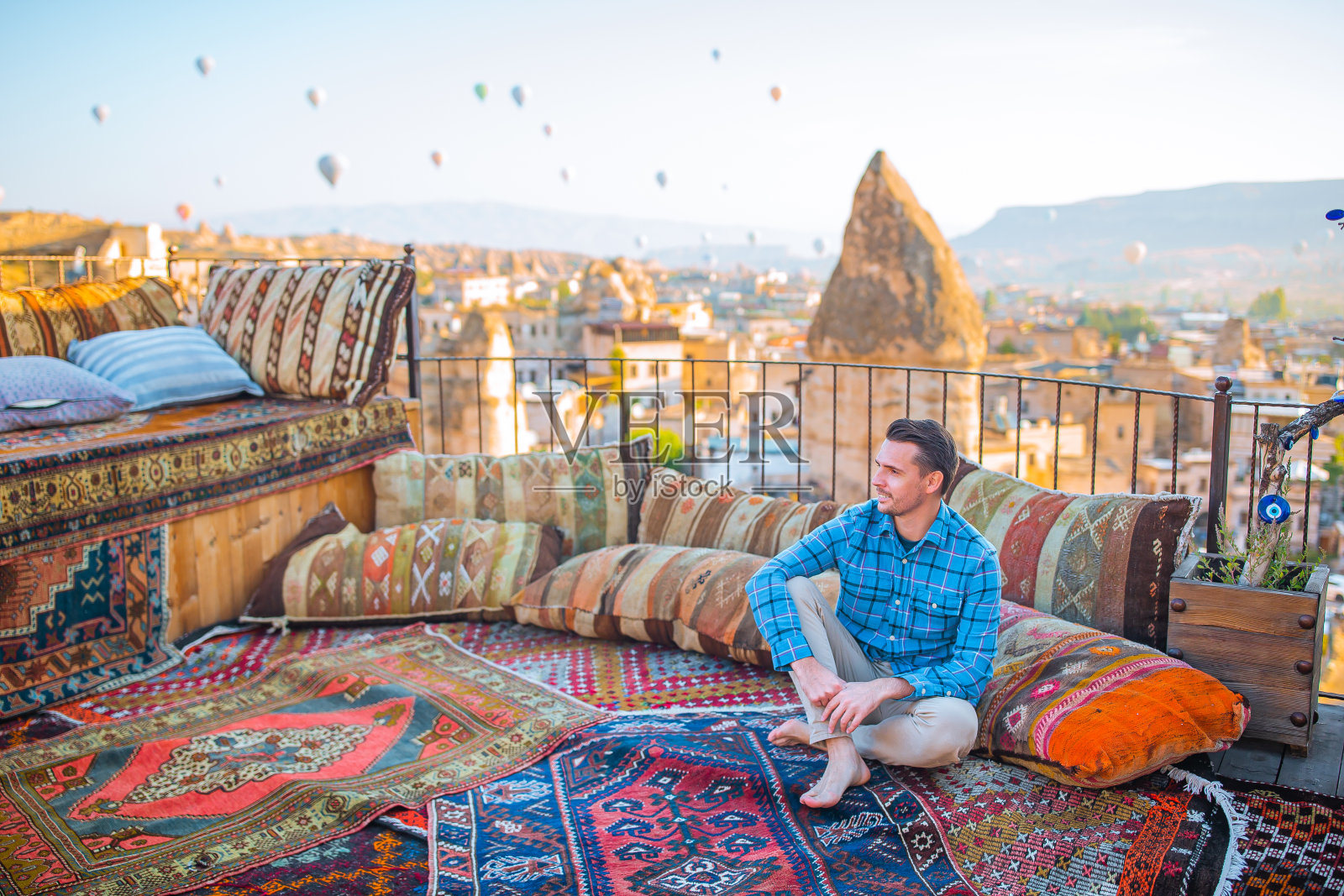 土耳其卡帕多西亚，一个快乐的年轻人在看热气球照片摄影图片