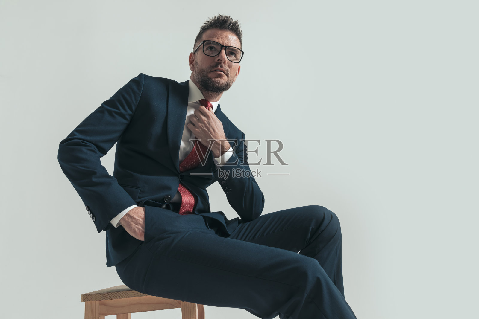 英俊的商人，西装革履，正在整理领带照片摄影图片