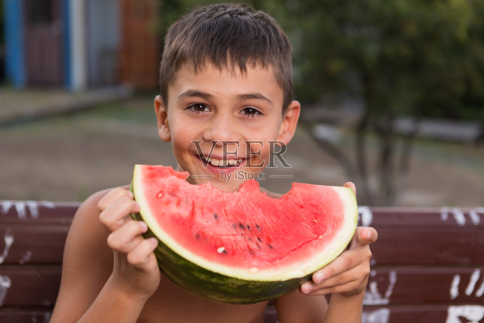 快乐少年吃红熟西瓜，户外，概念照片摄影图片