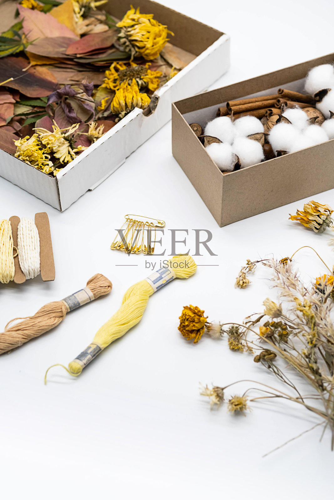 工作场所手工制作，爱好或DIY。天然材料，干叶，鲜花装在盒子里放在白色的桌子上。照片摄影图片