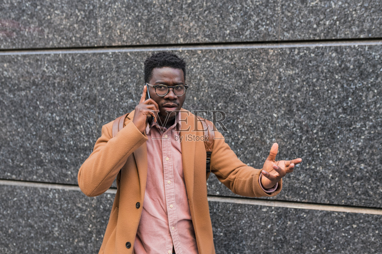 年轻的黑人男子在外面接电话时很沮丧照片摄影图片