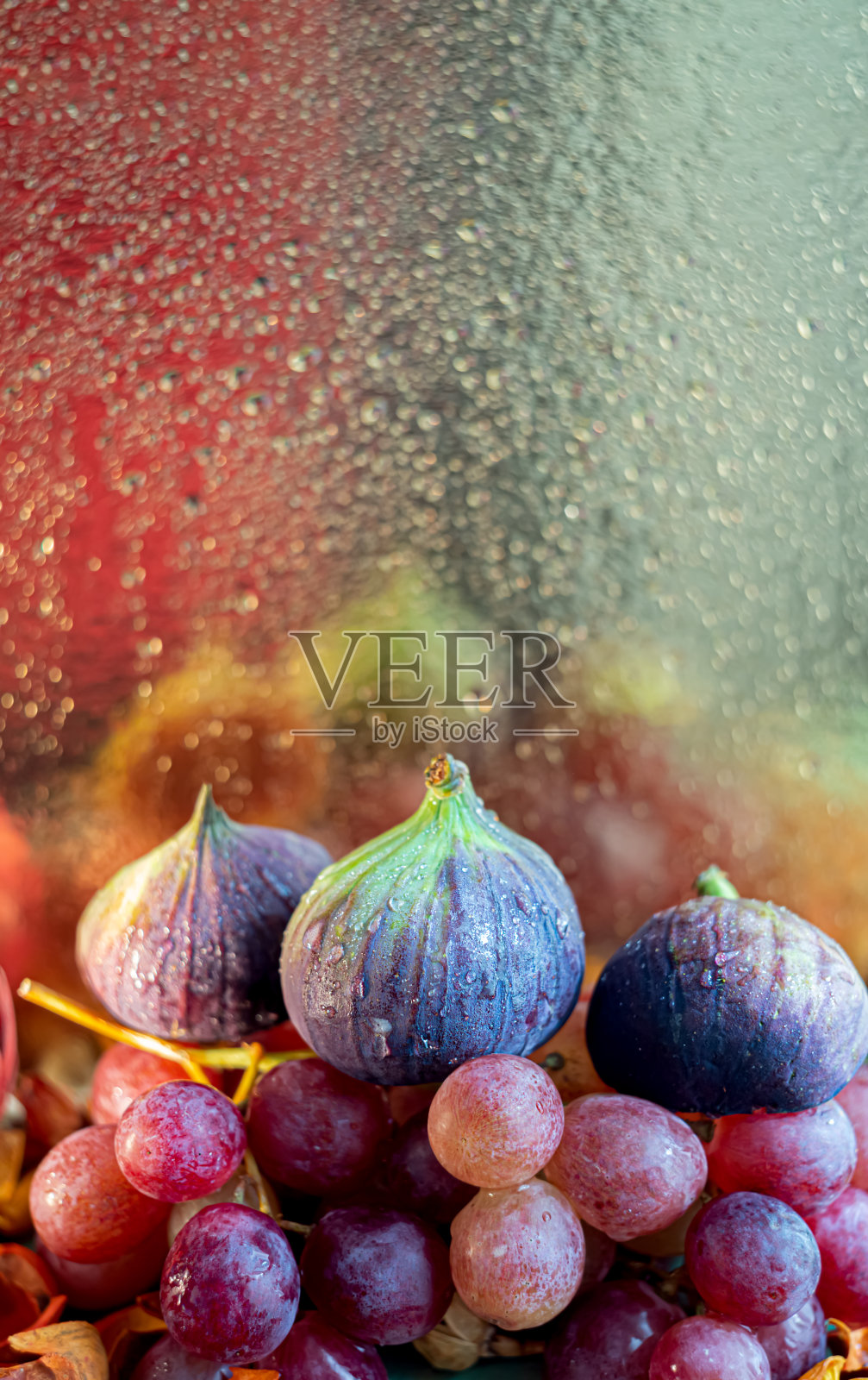 无花果和葡萄。秋天组成的水果和美丽的发光的散景上模糊的背景的水滴。照片摄影图片