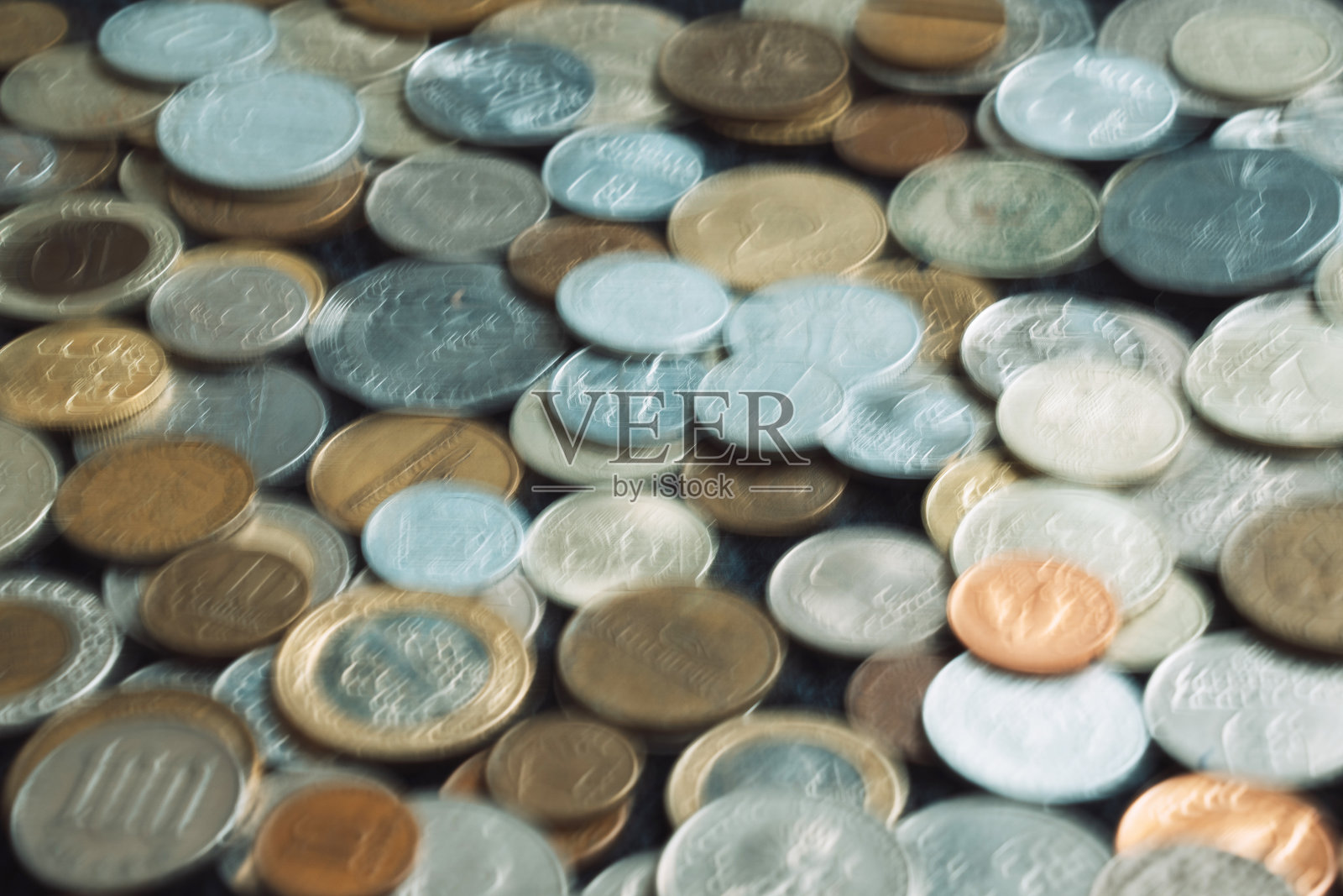 世界各国硬币的模糊照片。照片摄影图片