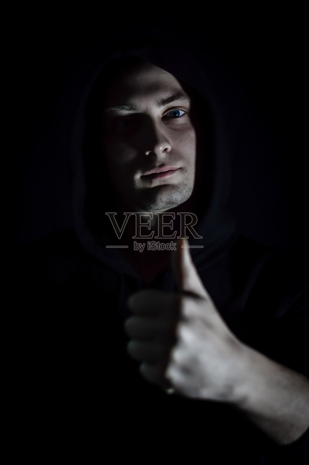 拇指向上-一个年轻的男子肖像帽谁在树荫下用他的手做一个赞成的迹象照片摄影图片