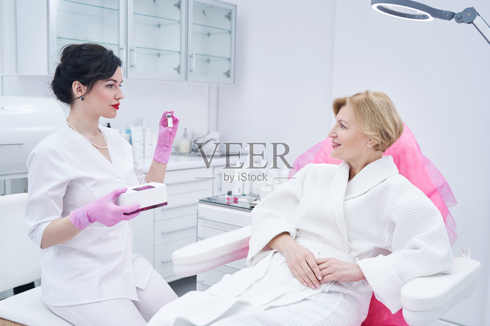 美容师在美容院向女士展示护肤品照片摄影图片