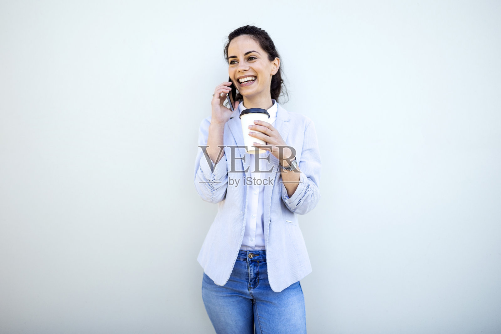 拿着咖啡杯煲电话粥的女商人照片摄影图片