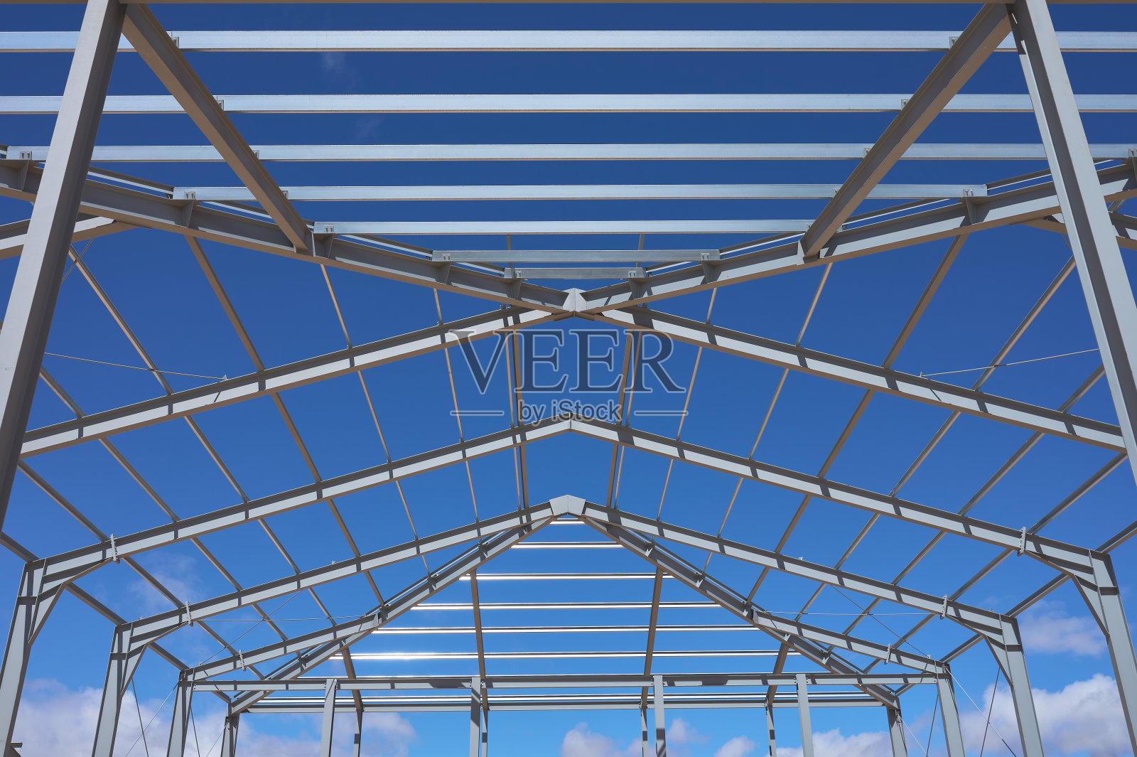 建筑物或船的金属结构在建筑的中间，有蓝色和多云的天空照片摄影图片