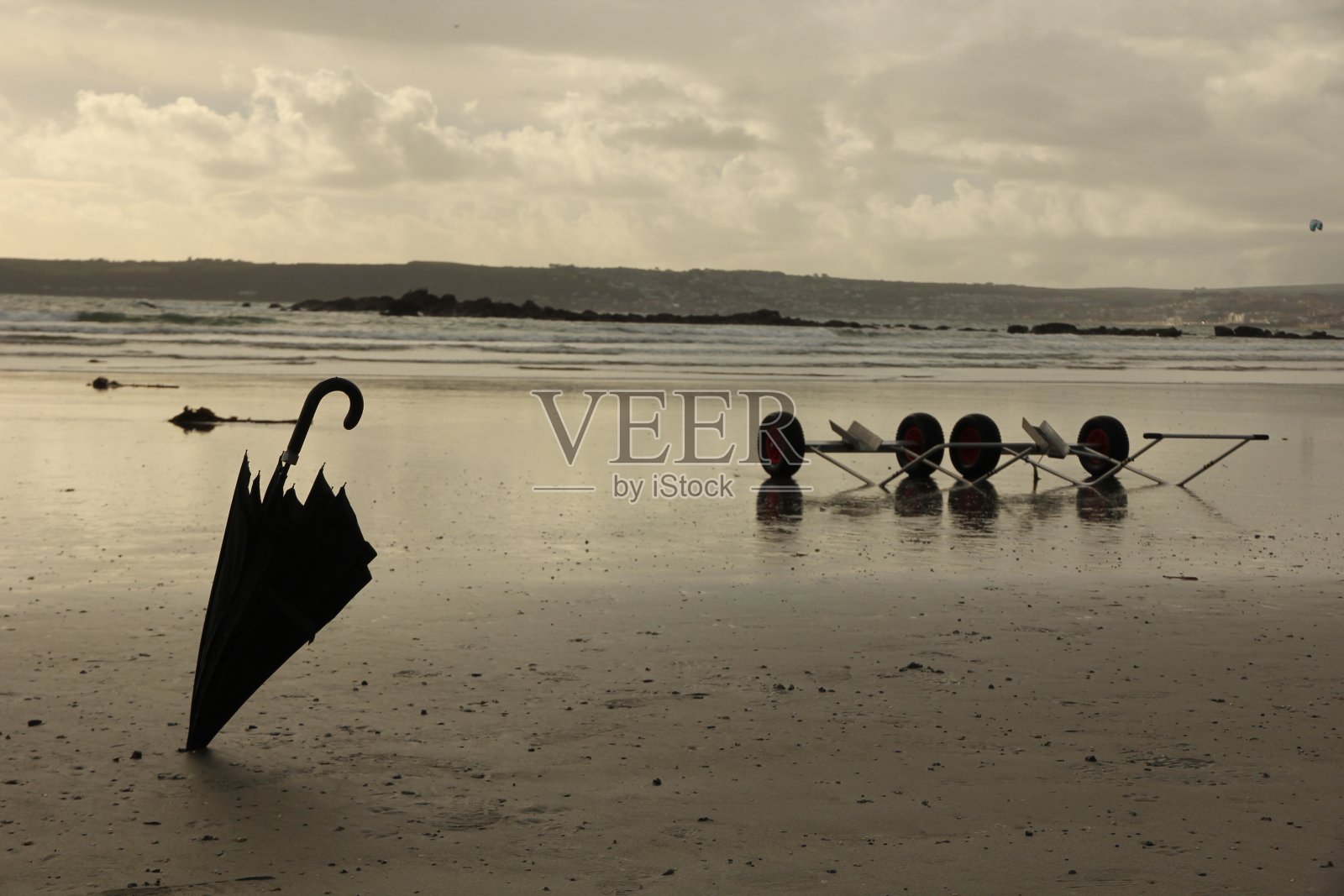 沙滩上的黑色折叠伞照片摄影图片