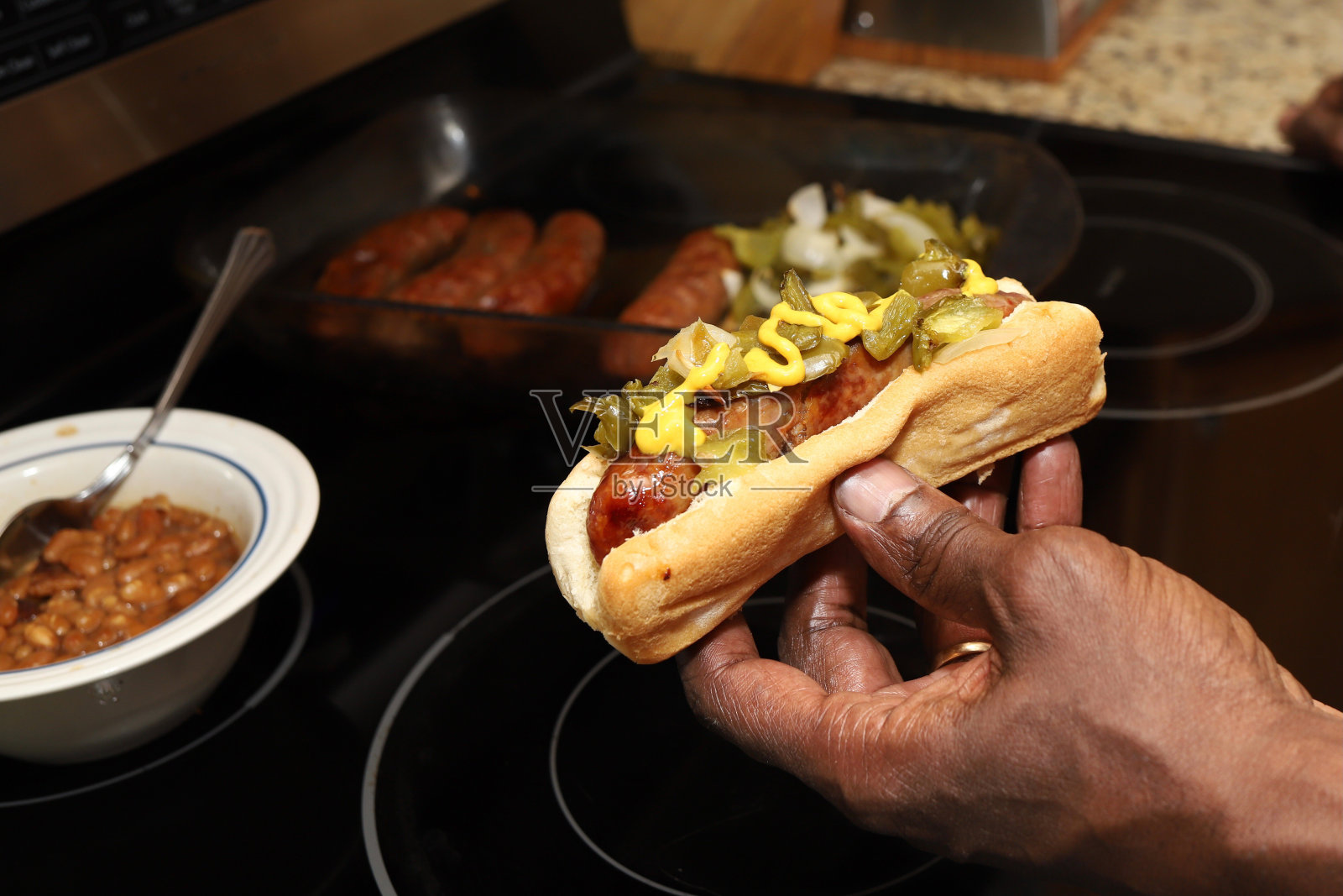 一名非裔美国黑人男子手里拿着意大利香肠和辣椒照片摄影图片