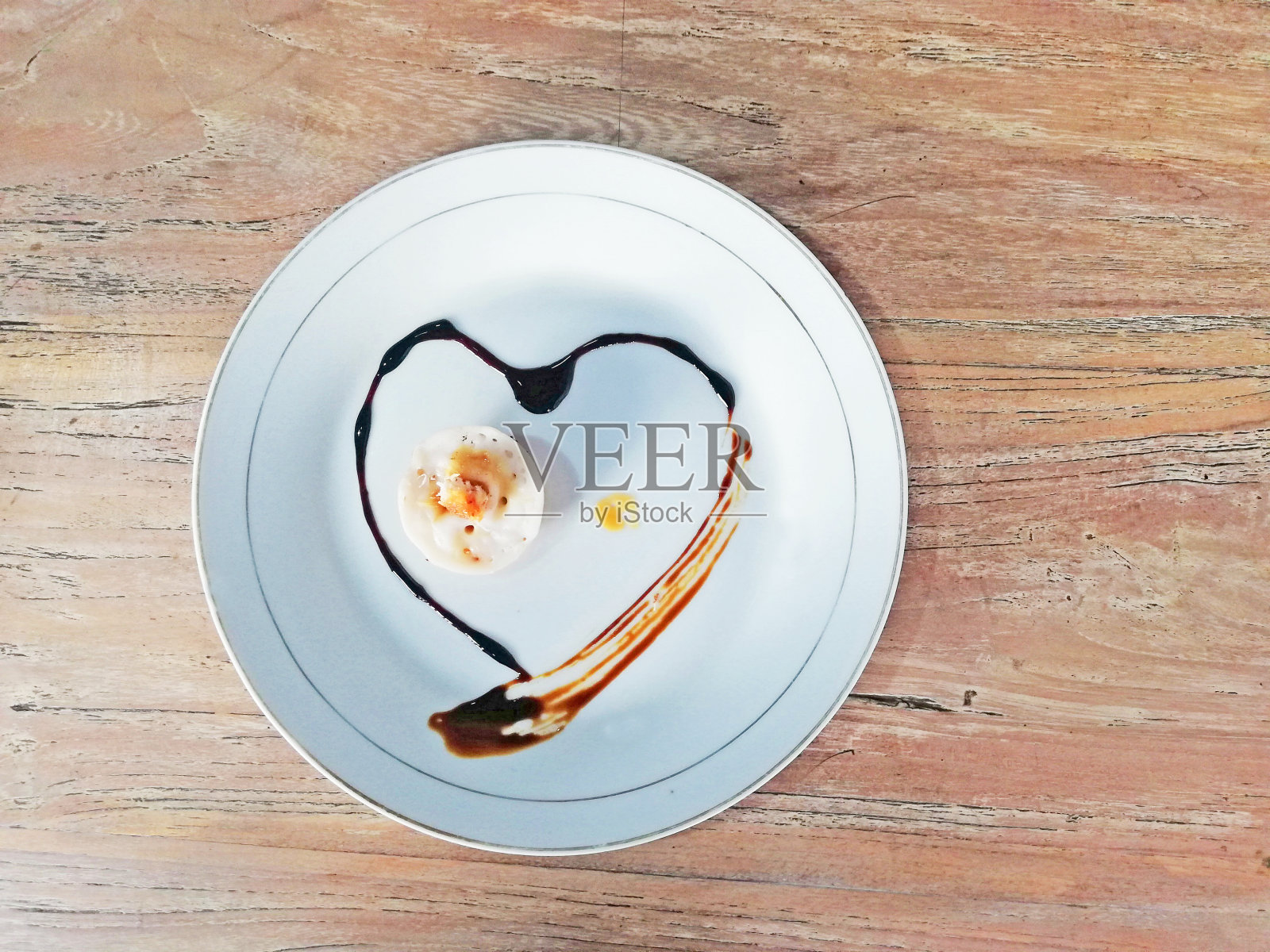 传统的巴厘岛印尼甜点名为“Kue Laklak”，盛在木制背景的白色盘子里照片摄影图片