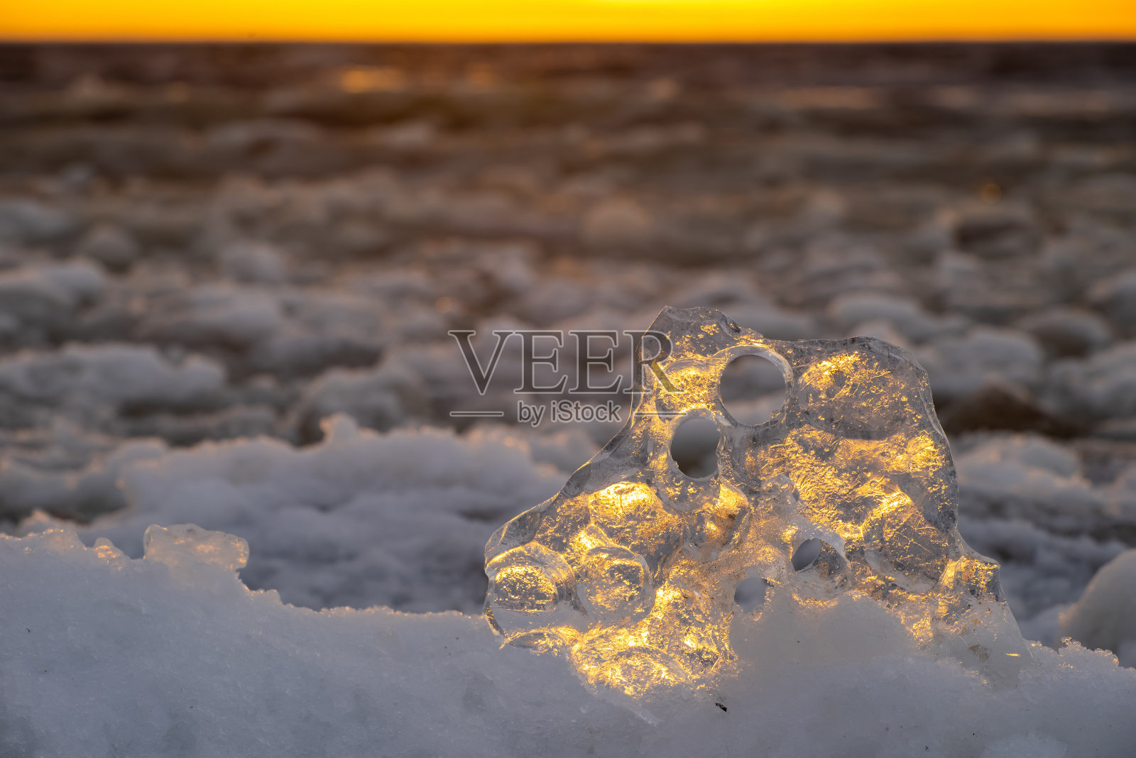 波罗的海岸边的雪上的一块冰的特写。照片摄影图片