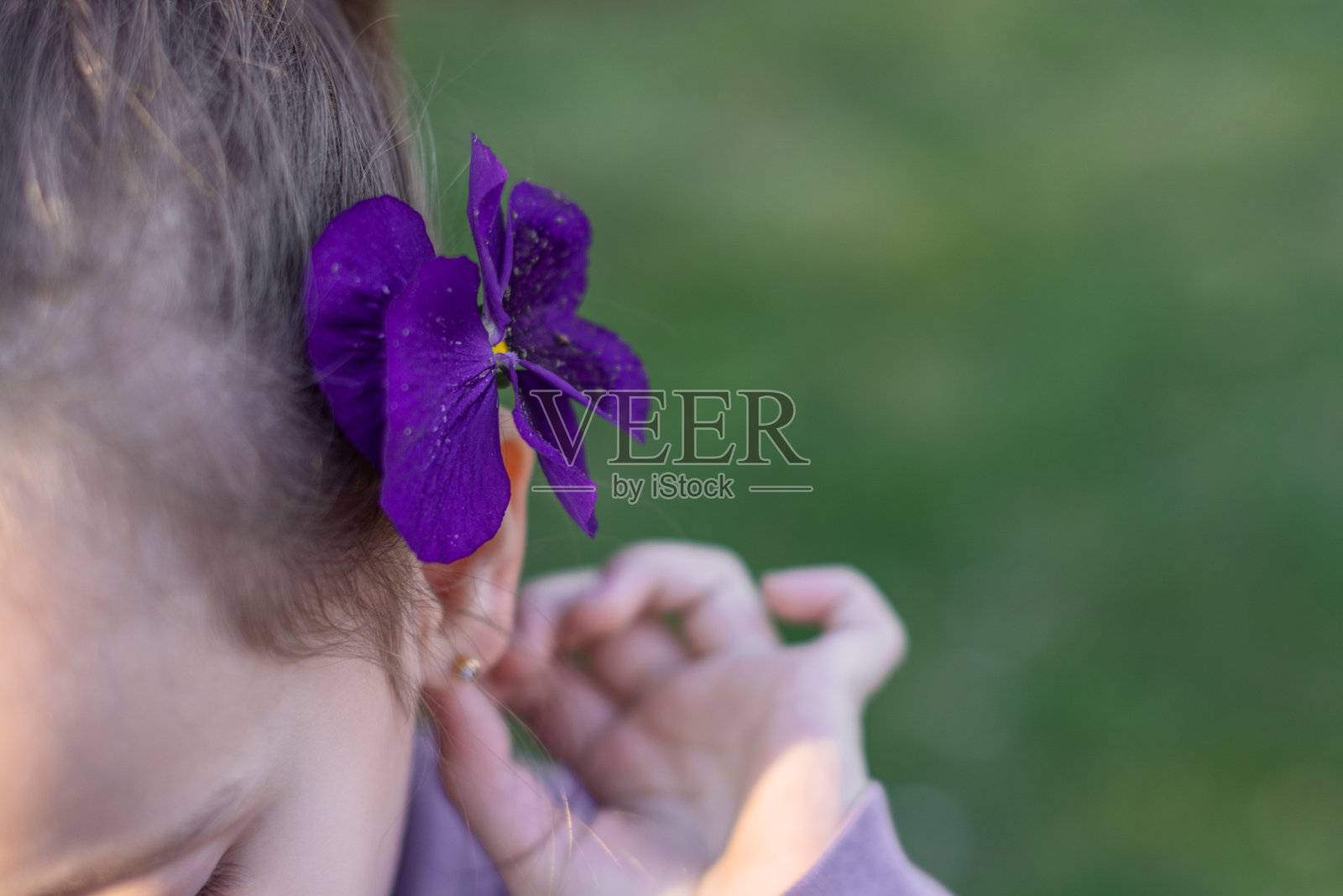 小女孩耳朵后面有朵花的特写照片摄影图片