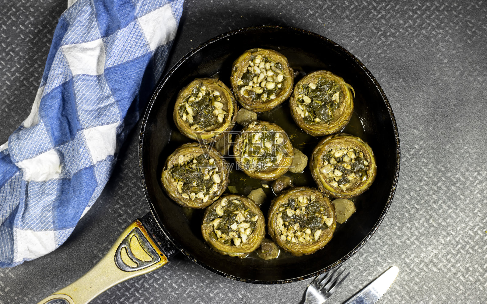 Sautéed和油炸洋蓟，大蒜和欧芹在锅上照片摄影图片