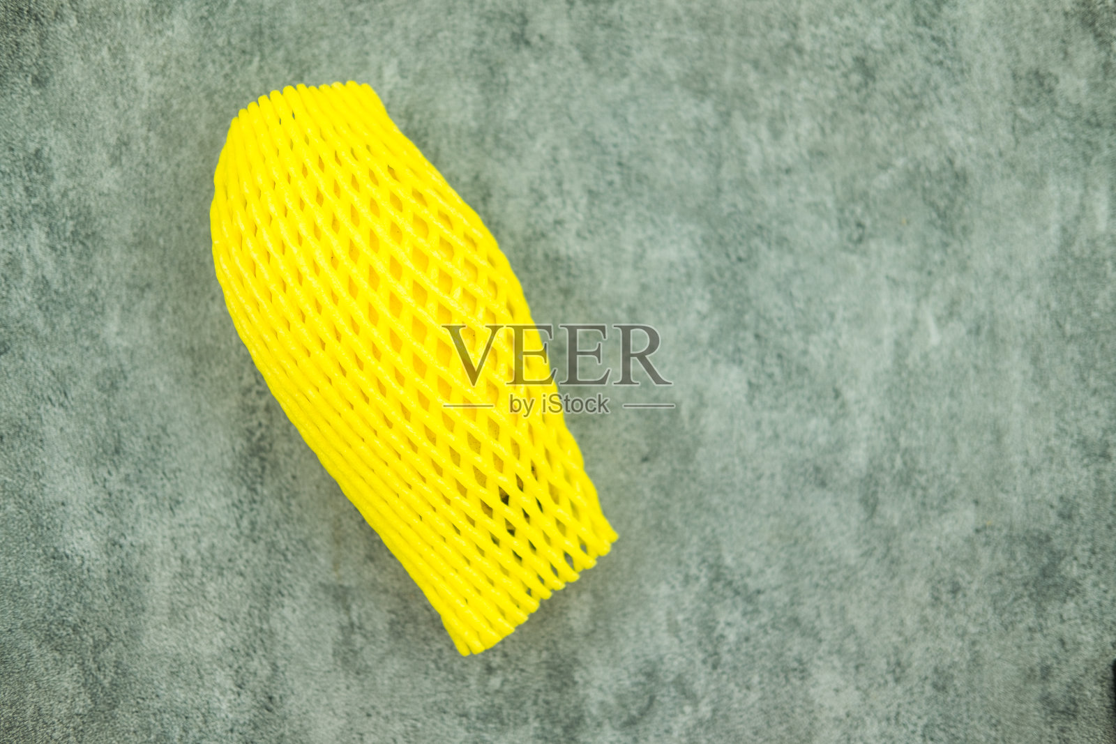 成熟的芒果，用黄色泡沫包裹芒果。照片摄影图片