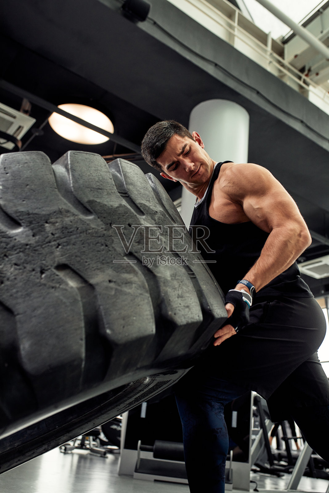 肌肉健美男子翻转轮胎。概念功能训练健身房照片摄影图片