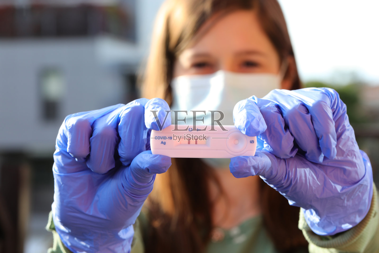 女医生的快速检测显示两条线，表明Covid-19诊断为阳性照片摄影图片