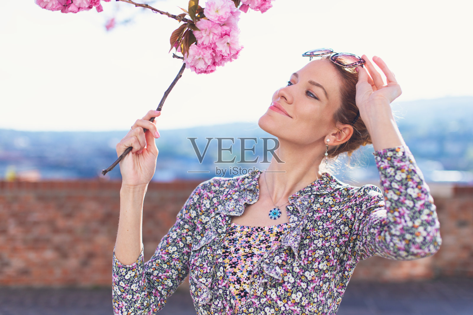 快乐的年轻女子与樱桃树枝摆姿势照片摄影图片