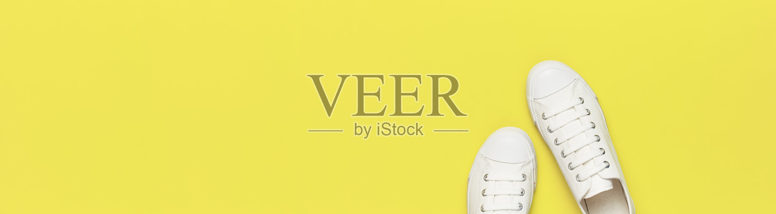 白色女性时尚运动鞋在黄色的背景。平面俯视图拷贝空间。女性的鞋子。时尚的白色运动鞋。时尚博客或杂志概念。简约的鞋子背景长横幅照片摄影图片