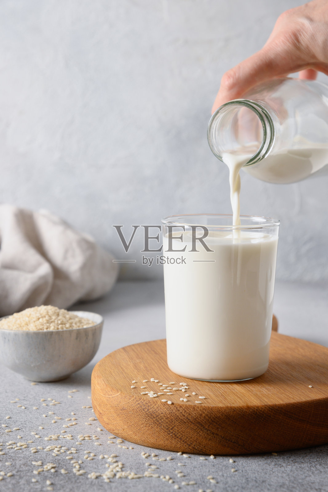 基于灰色背景的芝麻植物乳。关闭了。非乳制品的纯素食替代奶。照片摄影图片