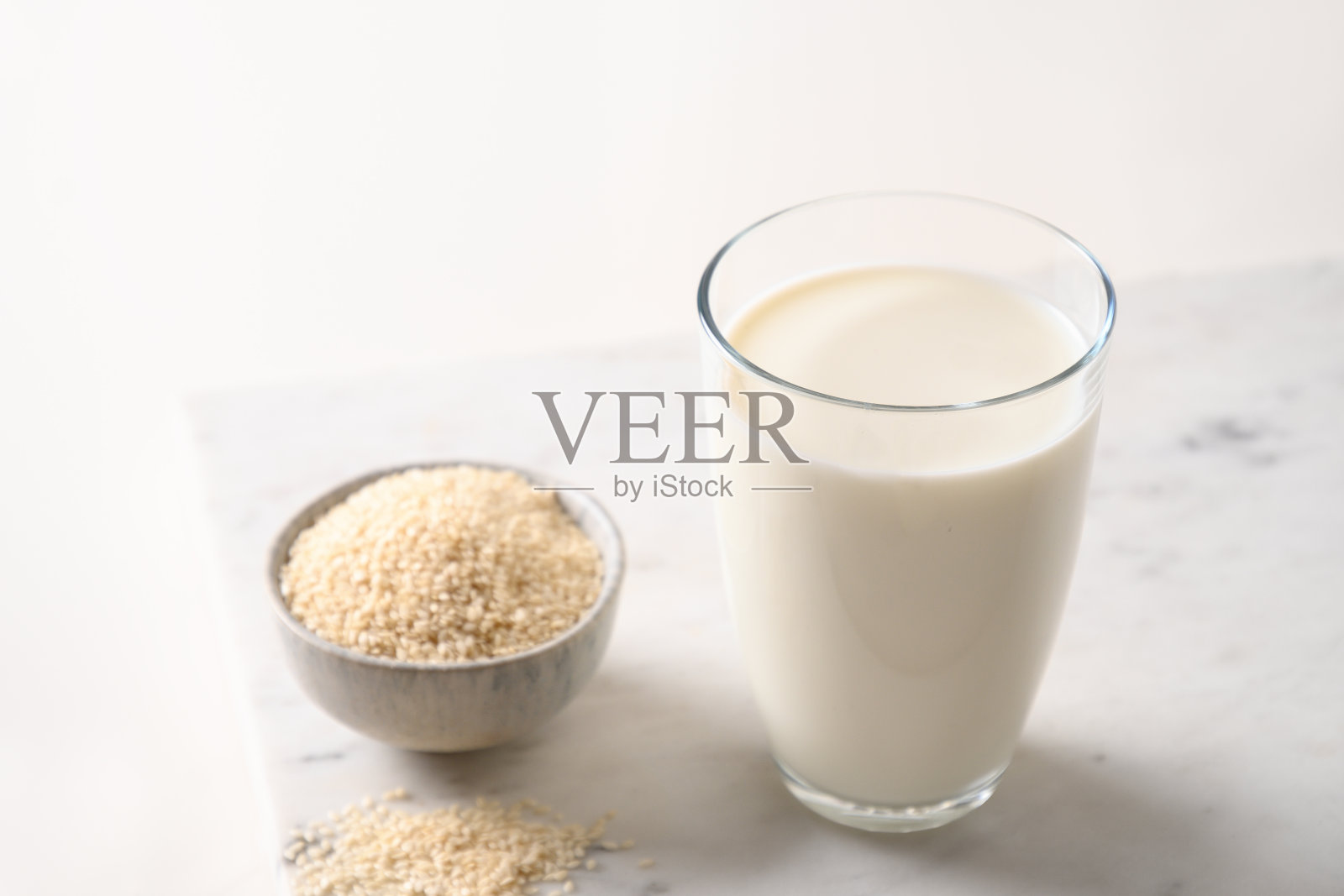 基于白色背景的芝麻植物牛奶。非乳制品的纯素食替代奶。照片摄影图片