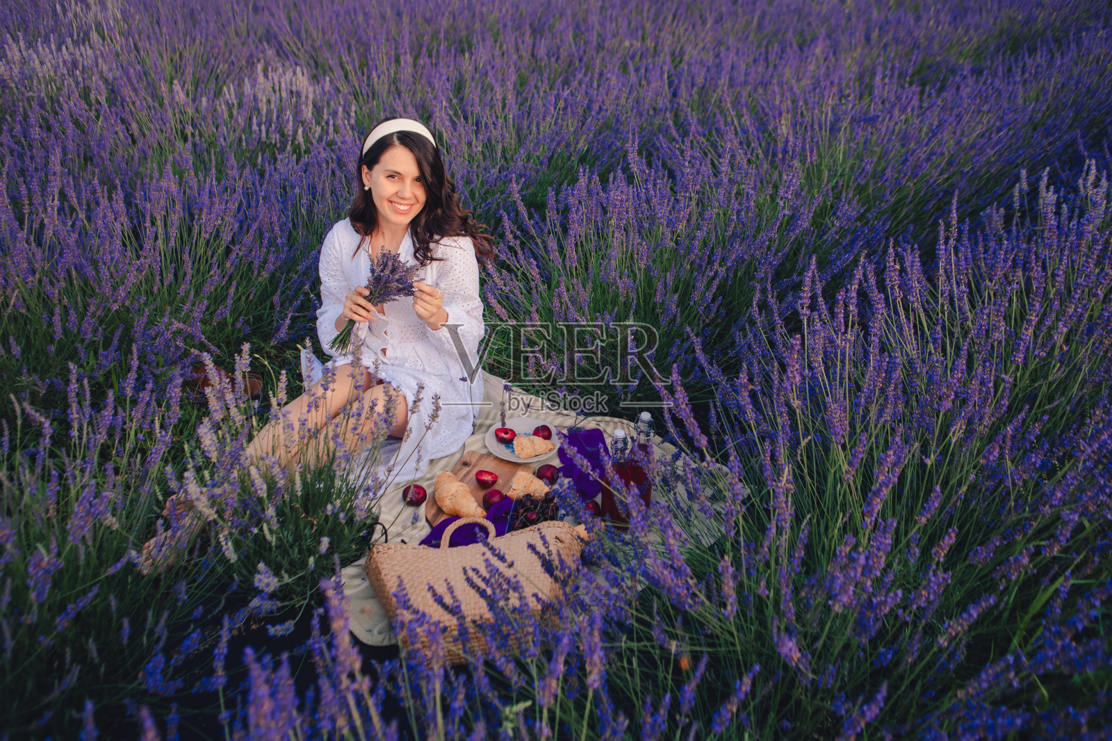 在薰衣草地里穿着白裙子的漂亮女人照片摄影图片