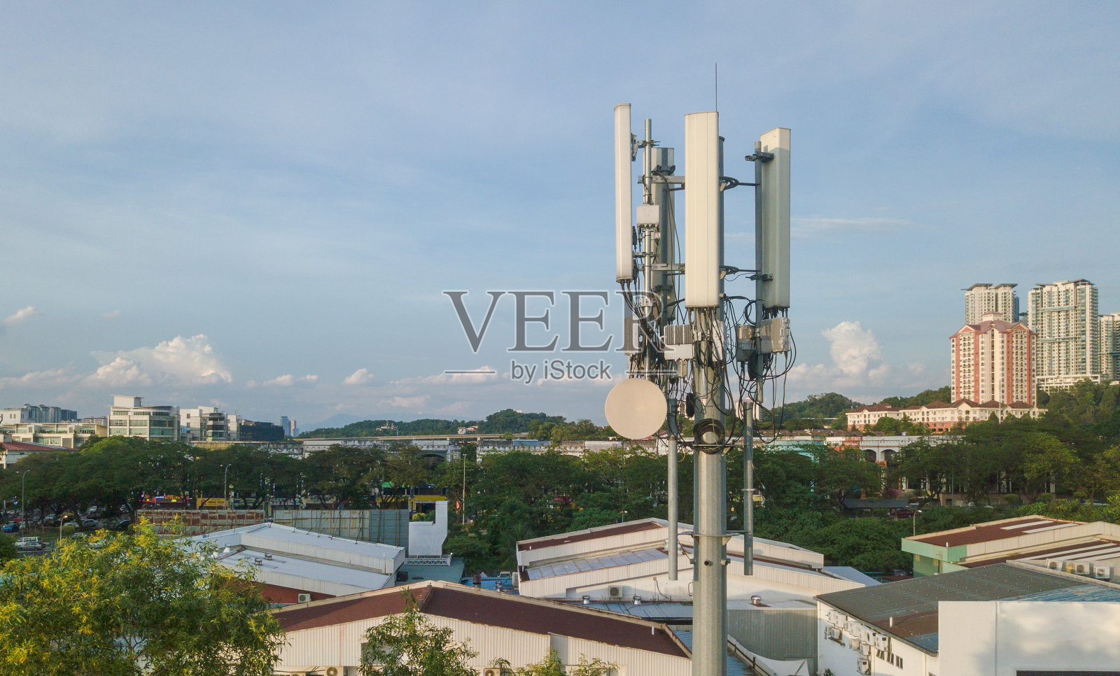 日落时分，现代城市中的5G塔照片摄影图片