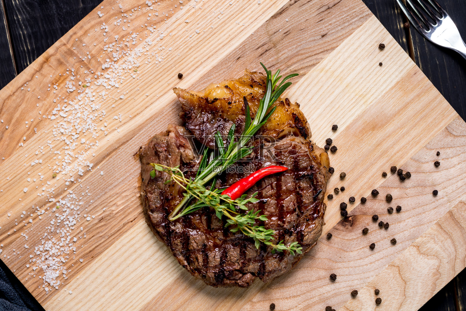 多汁的肋眼牛排，配上迷迭香和红辣椒照片摄影图片