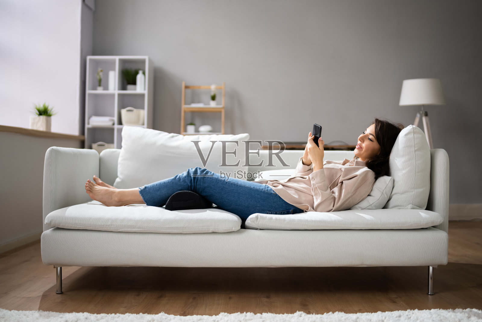 女人用脚垫来减轻背部压力照片摄影图片