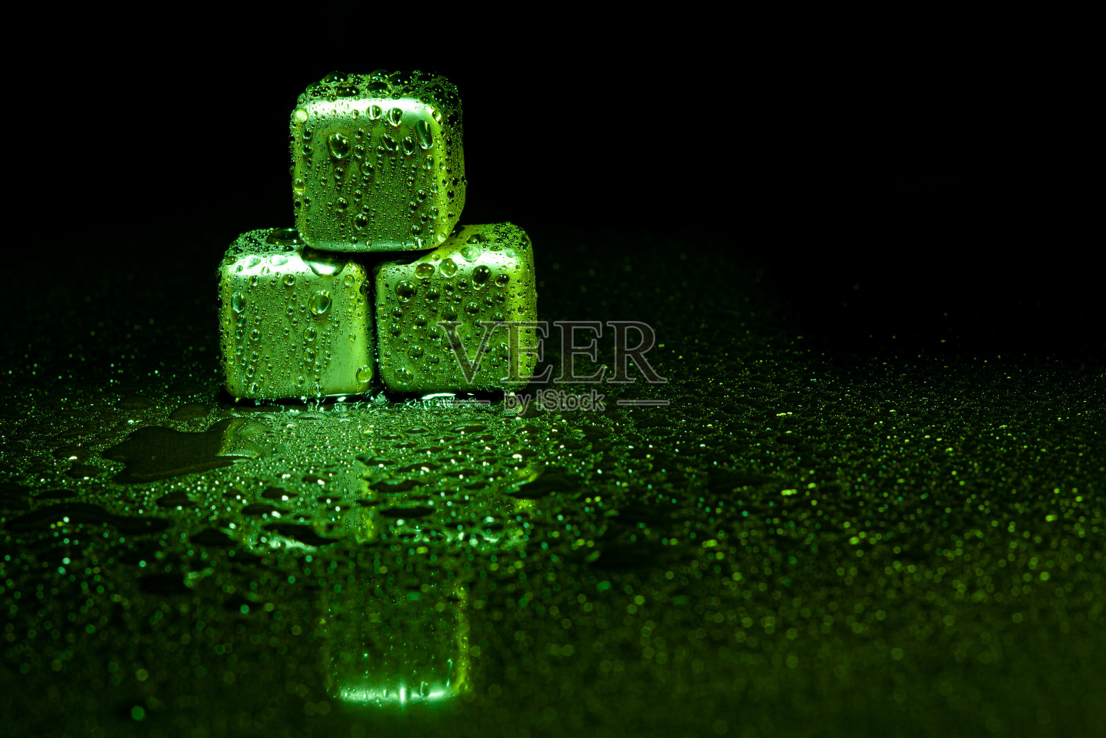 绿色不锈钢方块模拟冰在黑色表面与反射饮料。照片摄影图片