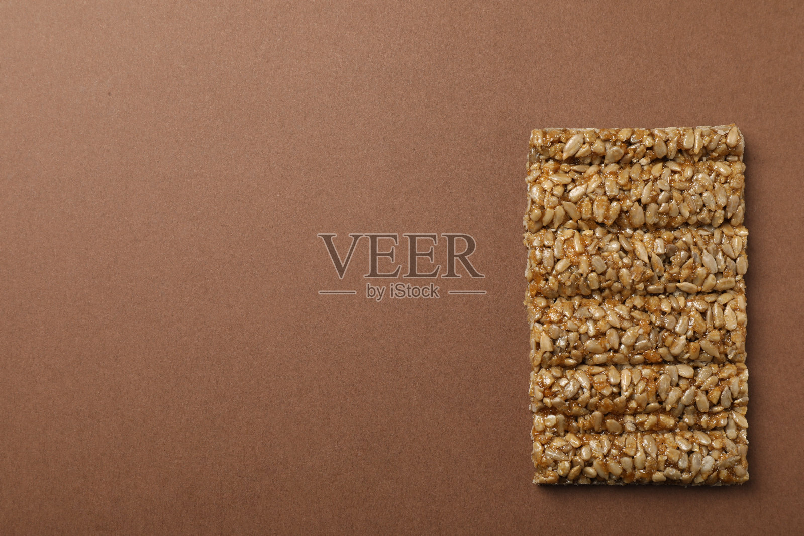 美味的kozinaki酒吧在棕色背景，俯视图。空间的文本照片摄影图片