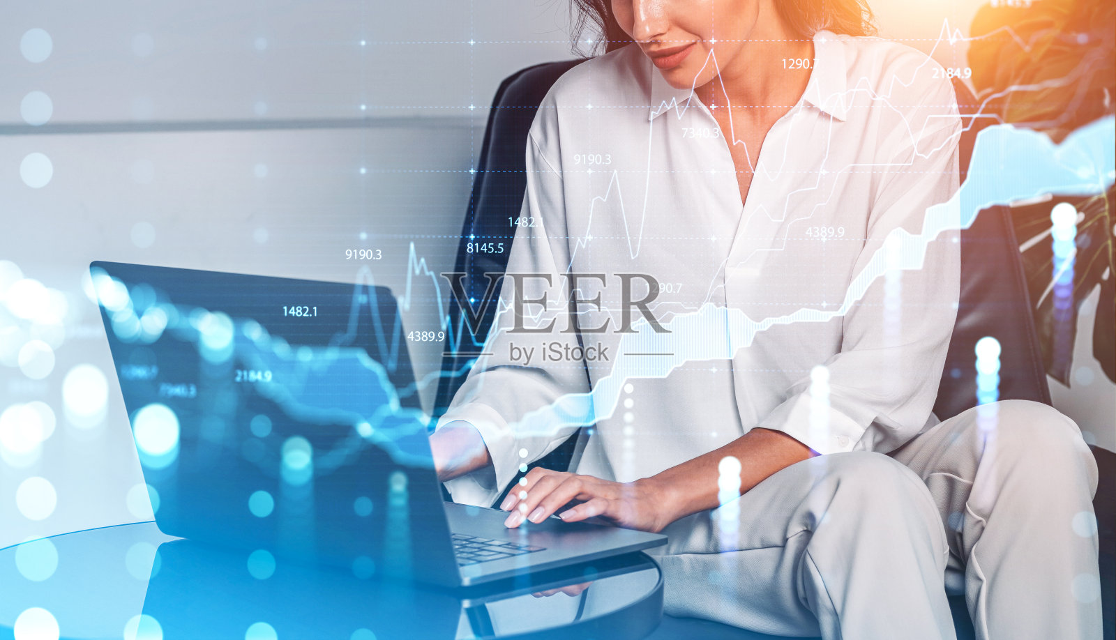 商务女性工作与笔记本电脑在办公桌在办公室，外汇图表照片摄影图片