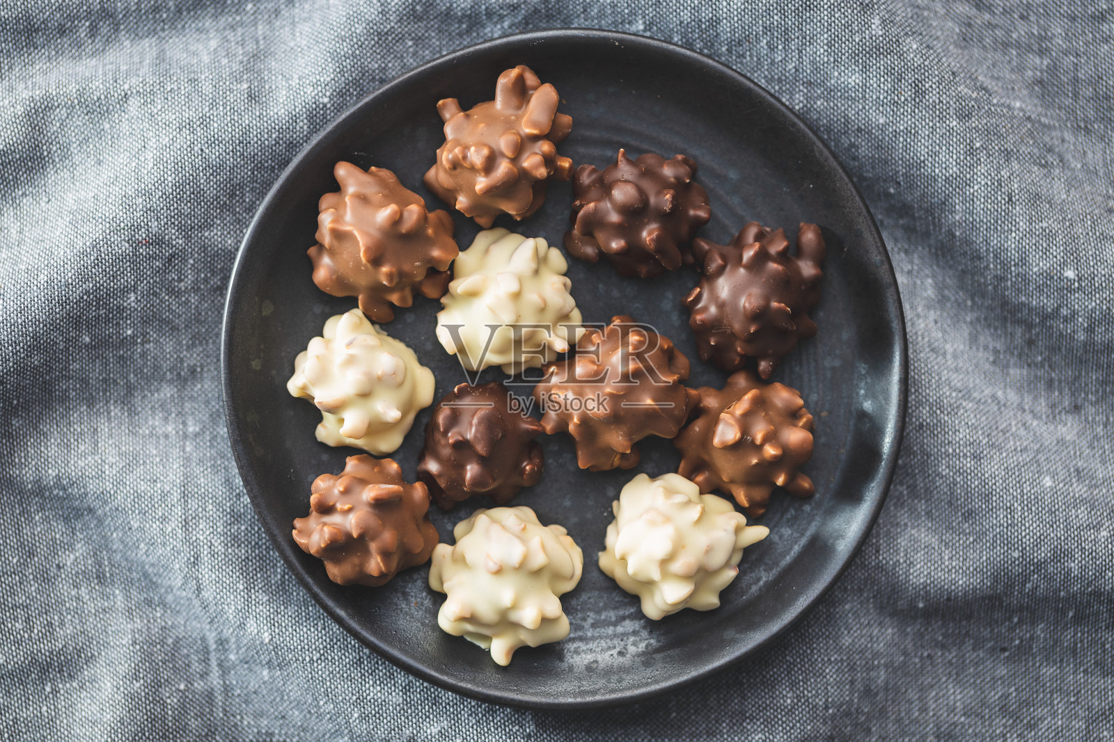 巧克力松露。盘子里有甜果仁糖。照片摄影图片