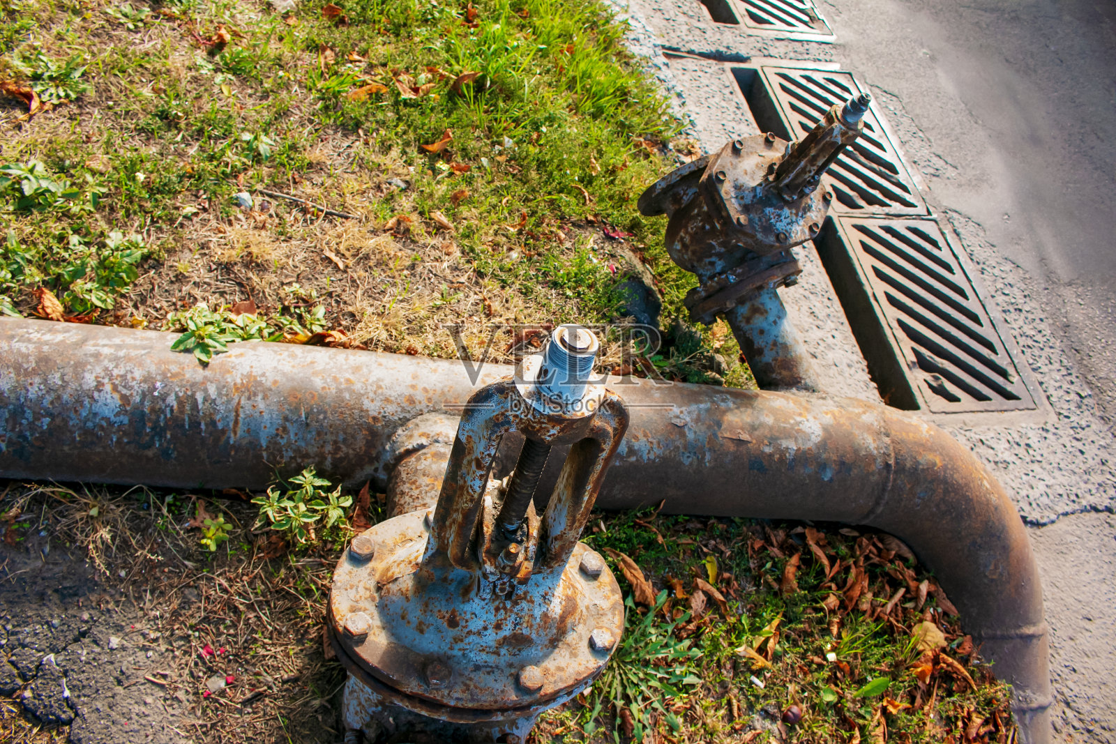 背景上生锈的旧水龙头和供水管道。照片摄影图片