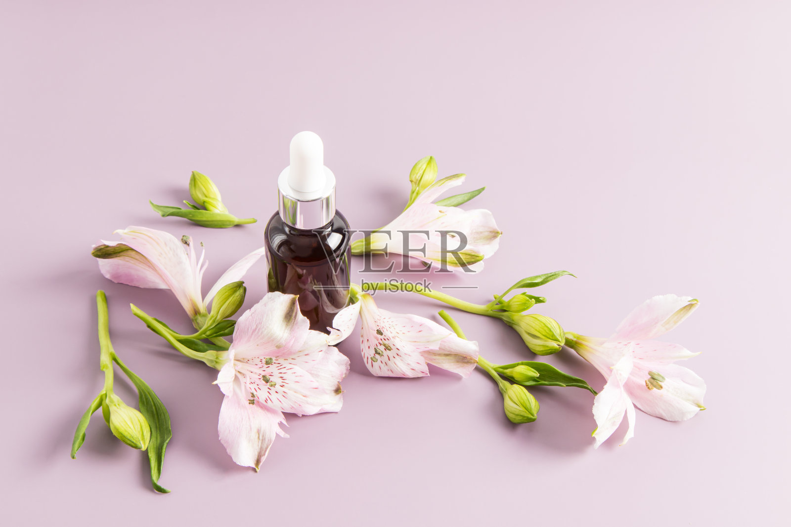 玻璃化妆品瓶与piptka分配器的医疗和化妆品使用的紫色背景与精致的颜色。照片摄影图片