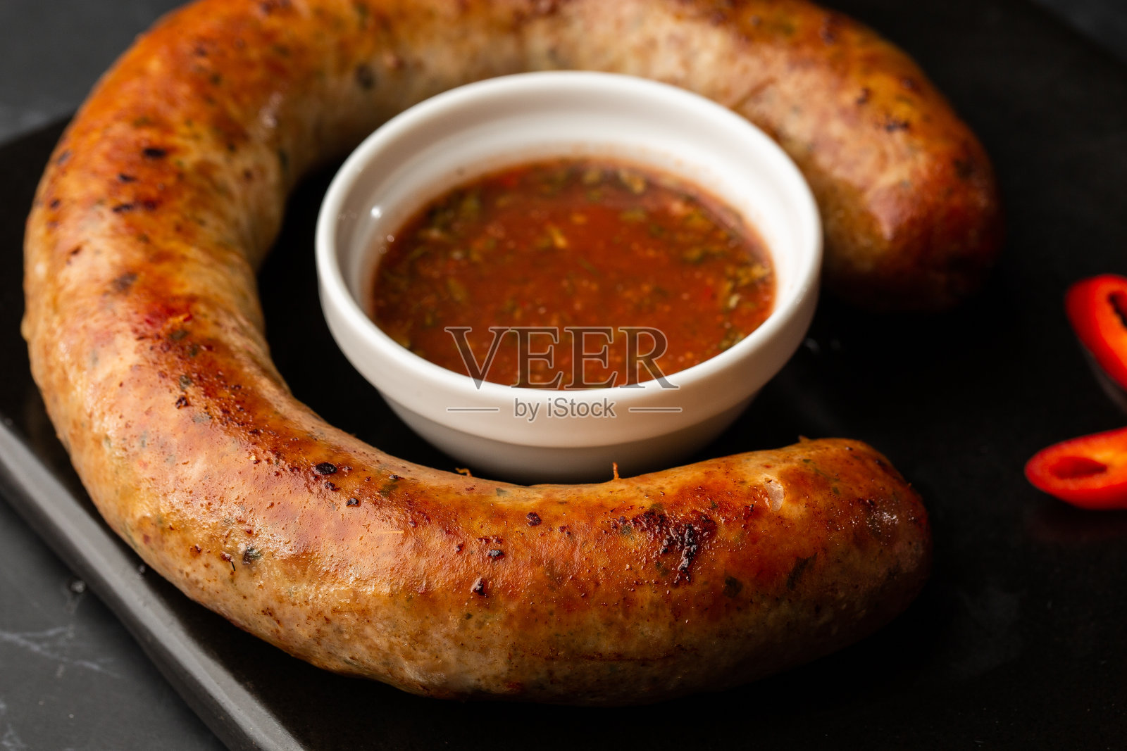 多汁的自制烤香肠，配上辣酱和腌洋葱，大理石背景照片摄影图片