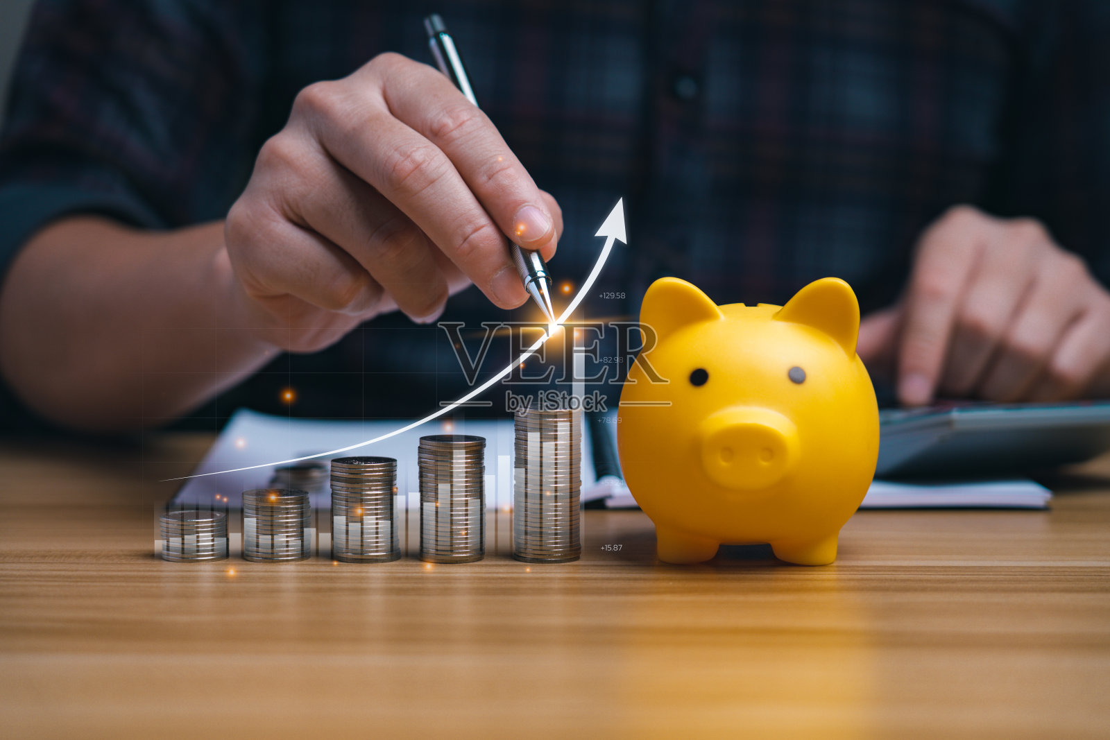 商人分析外汇交易图表财务数据。存钱罐里有硬币，桌子上有箭头显示图表。货币增长和商业金融的概念，成功的投资策略照片摄影图片