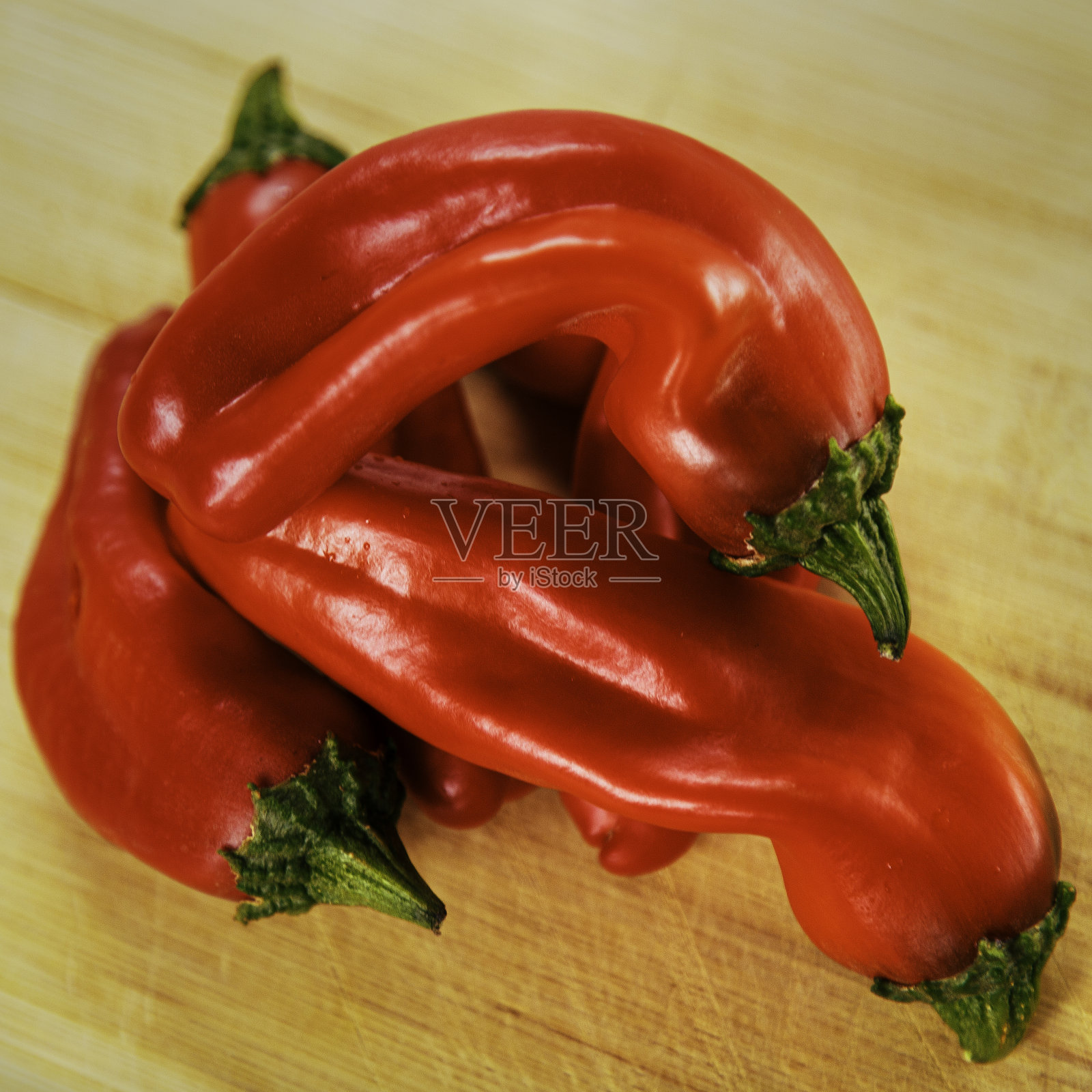 透过窗户的光线，桌子上放着鲜红可口的新墨西哥辣椒。照片摄影图片