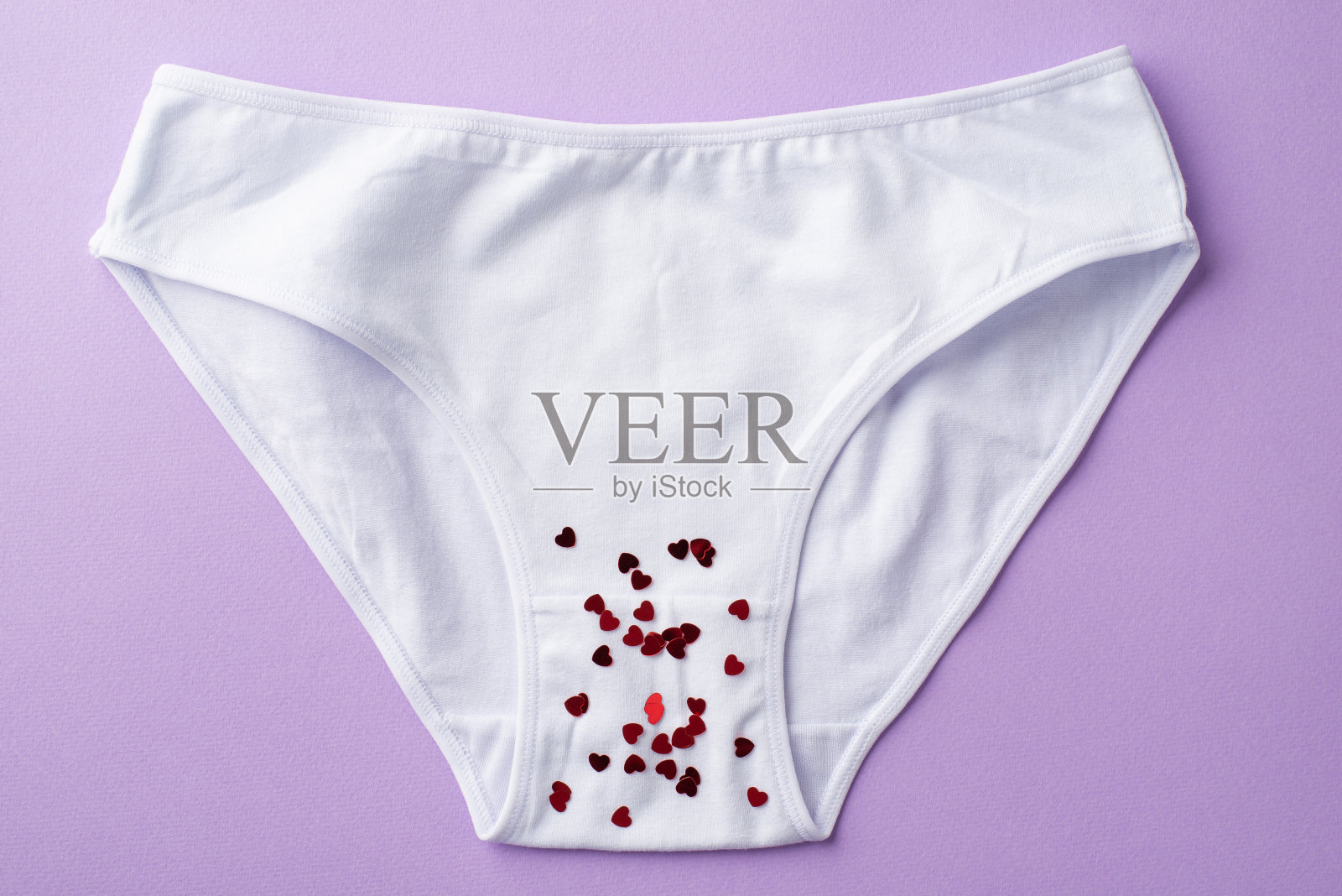 顶视图照片的白色棉花经典内裤与红心形状的彩纸上孤立粉彩淡紫色的背景照片摄影图片